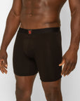 Man wearing black Spicy Wear boxer briefs with a red logo on a light gray background
