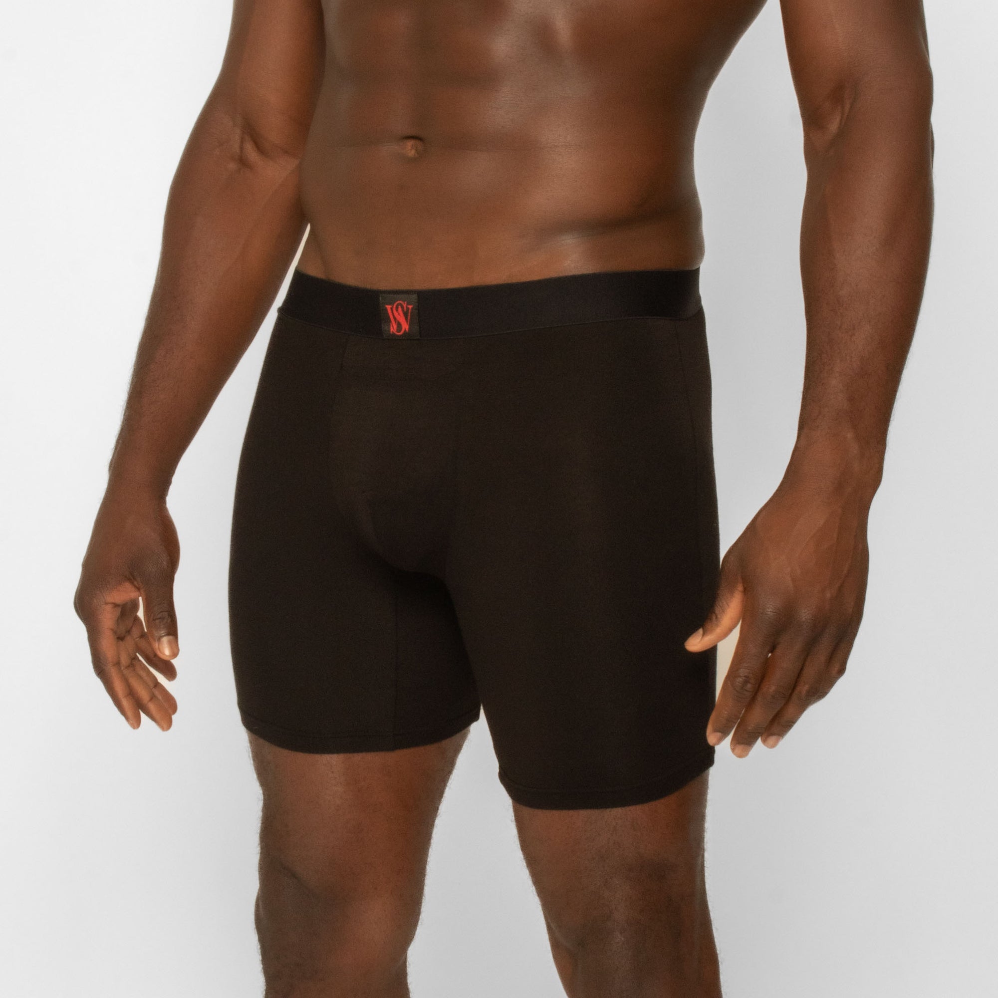 Man wearing black Spicy Wear boxer briefs with a red logo on a light gray background
